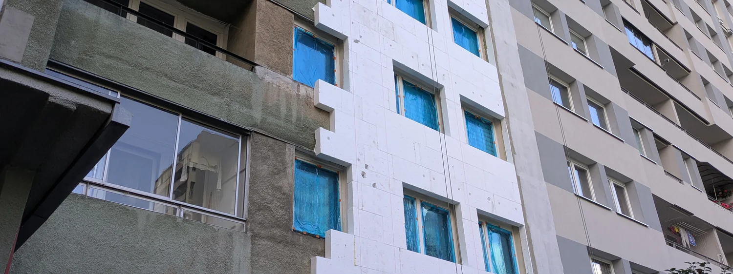 Fațadă de clădire în curs de izolare cu plăci rigide de polistiren