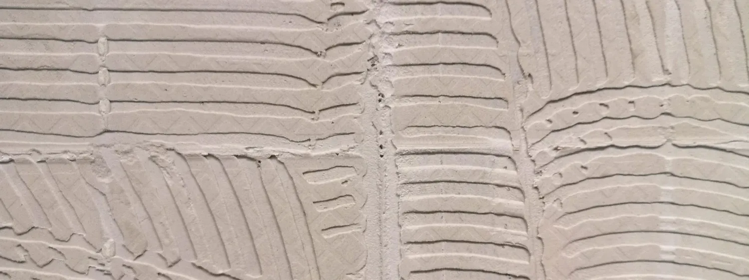 Urme de adeziv vechi pe un perete după îndepărtarea plăcilor ceramice