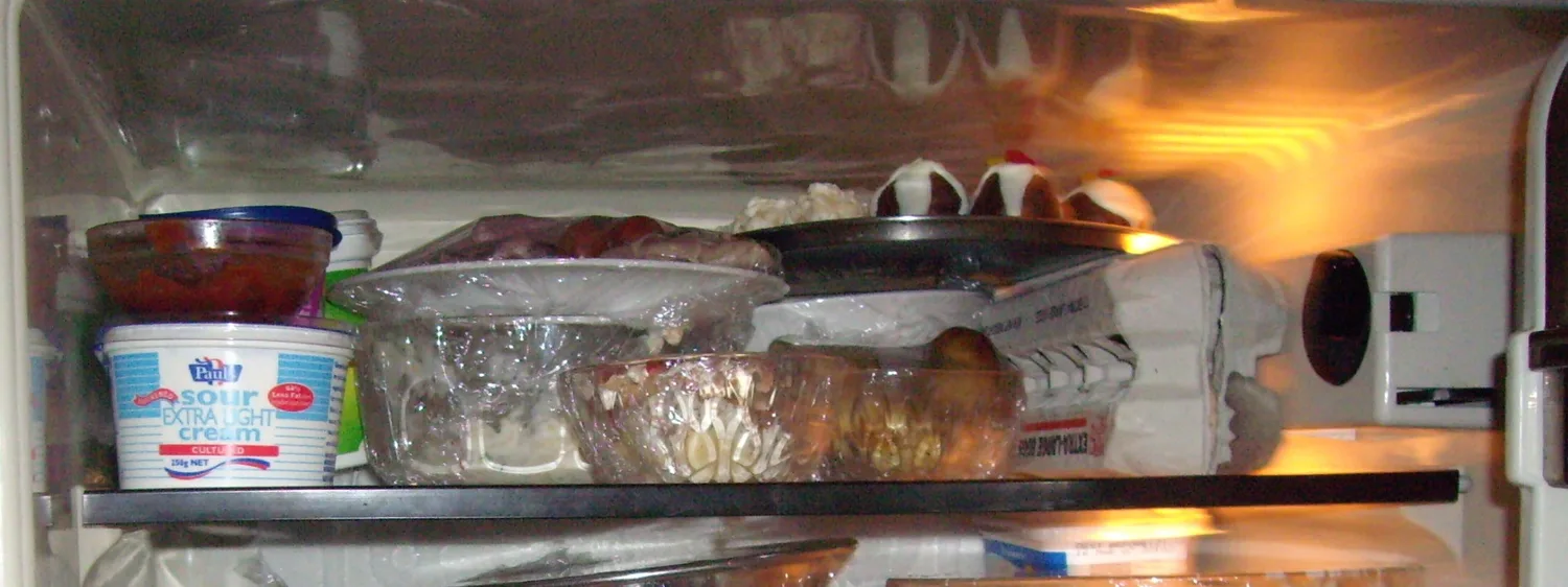 Rafturile unui frigider casnic cu alimente și iluminare interioară