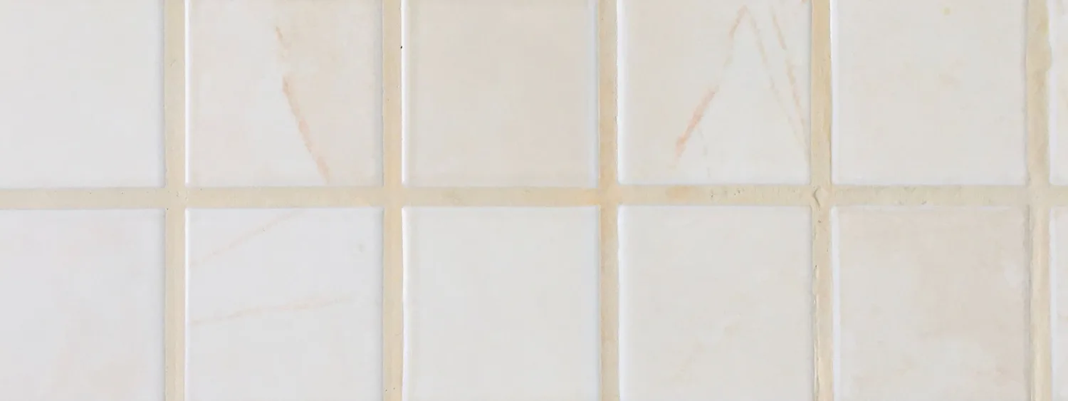 Plăci ceramice pătrate deschise la culoare, separate de rosturi vizibile