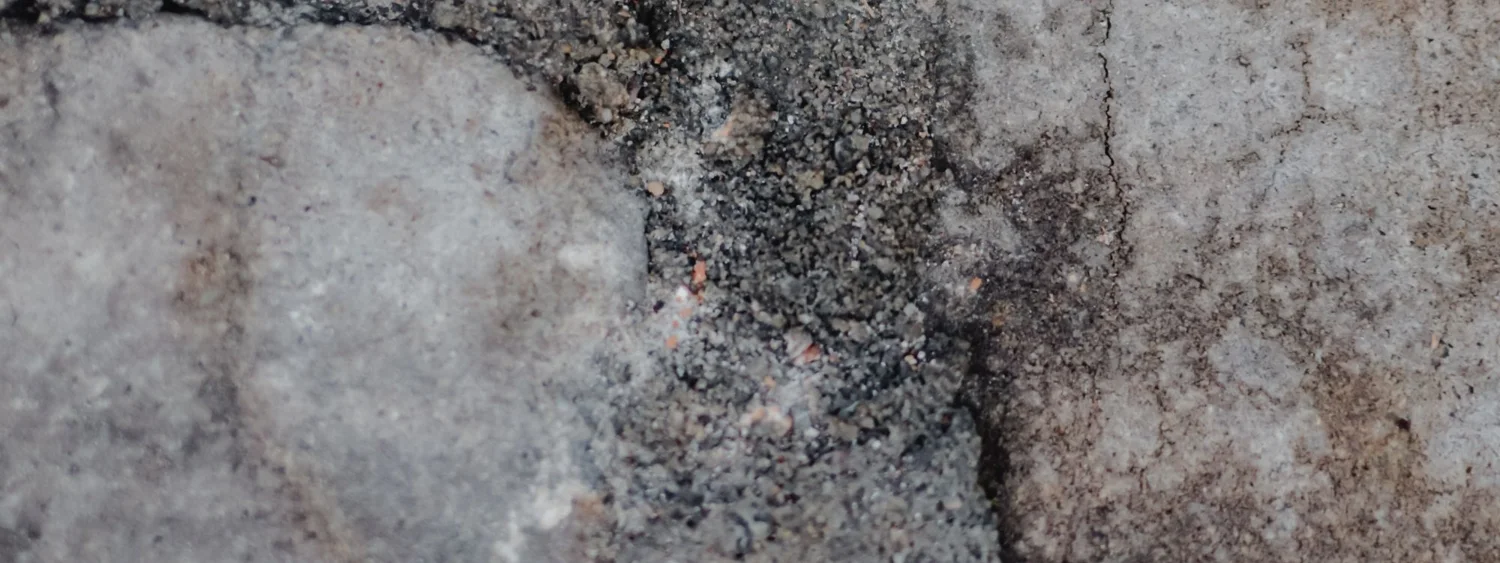 Fisuri pe o suprafață minerală cenușie